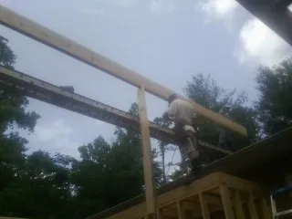Carpenter setting a ridge beam over a new addition frame — Ice Dam Removal by Roofing Brothers in Sioux Falls