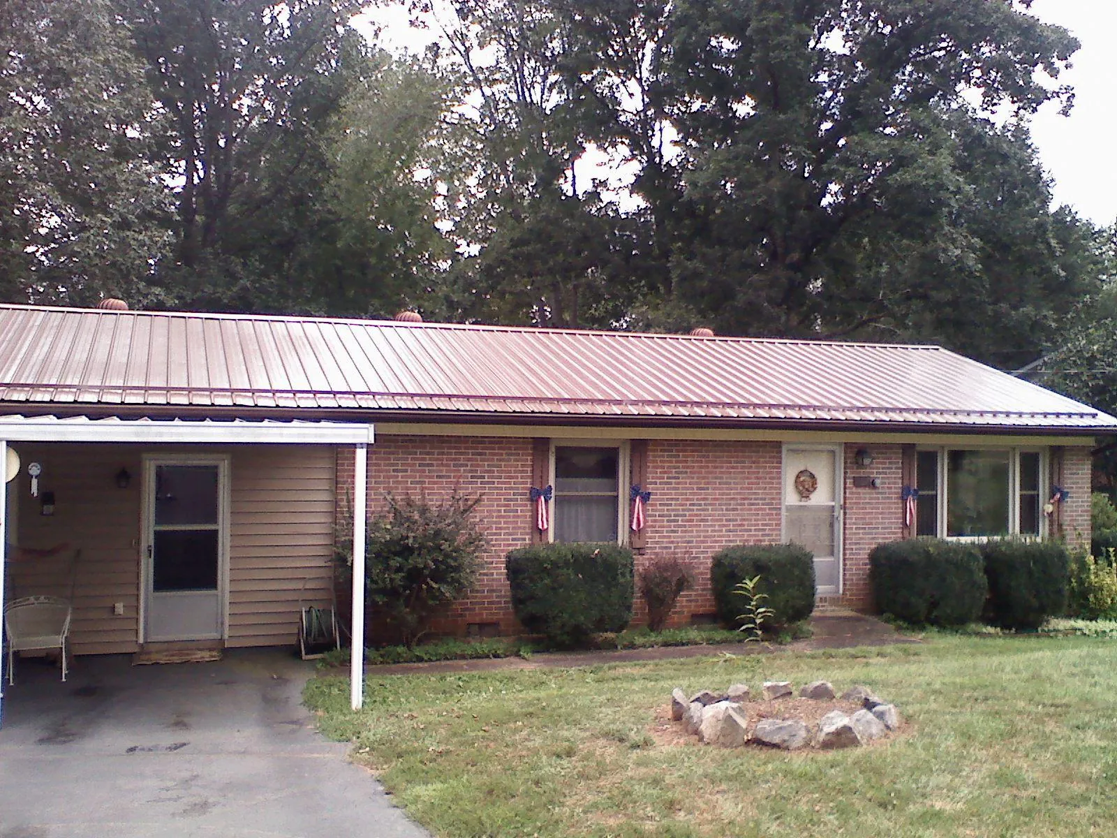 Bronze metal roof and carport on a brick ranch home — Roof Repair work by our crew in Sioux Falls