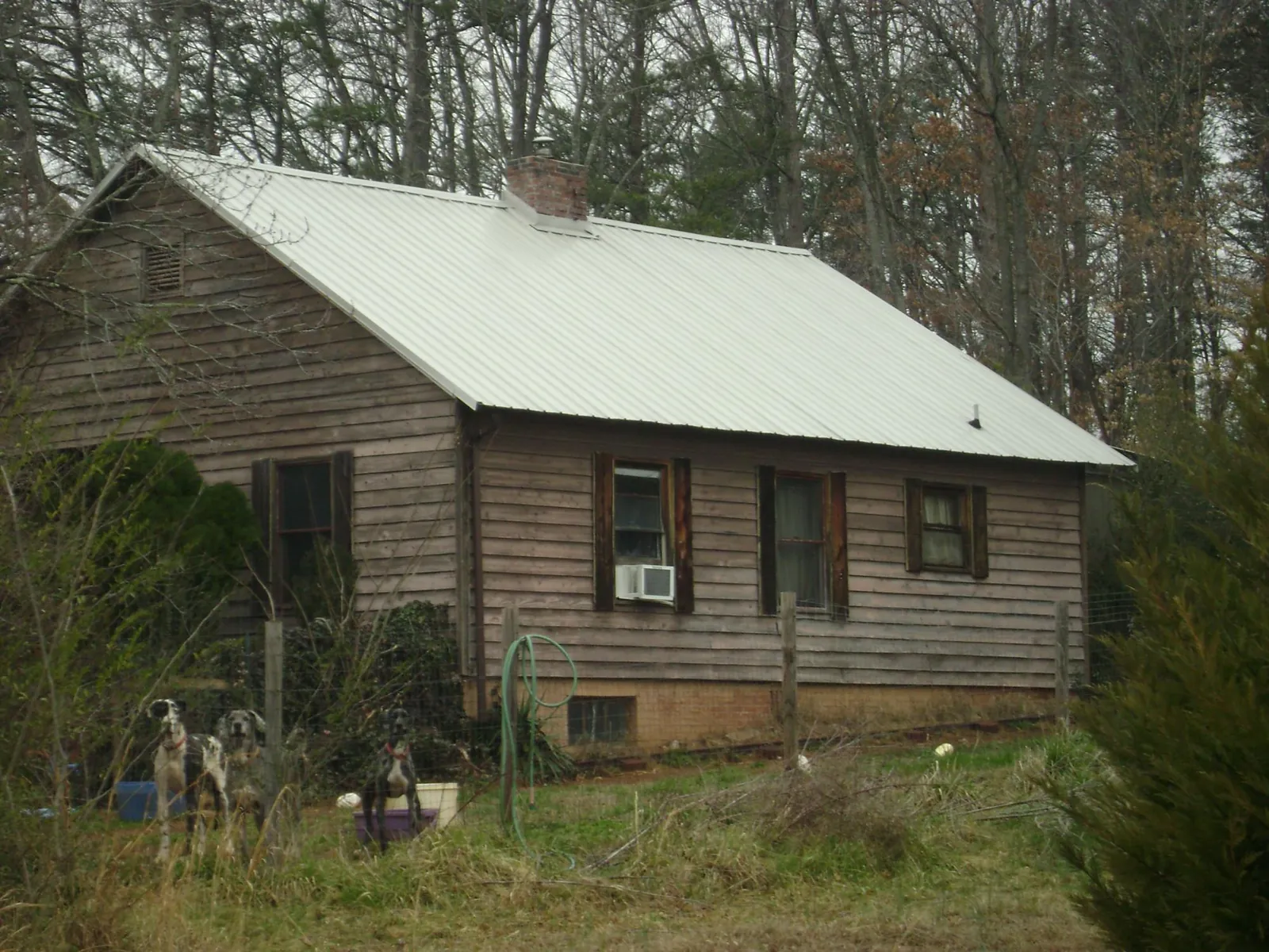 White metal roof on an old wood sided farmhouse, from a Asphalt Shingle Roof Repair job in Sioux Falls
